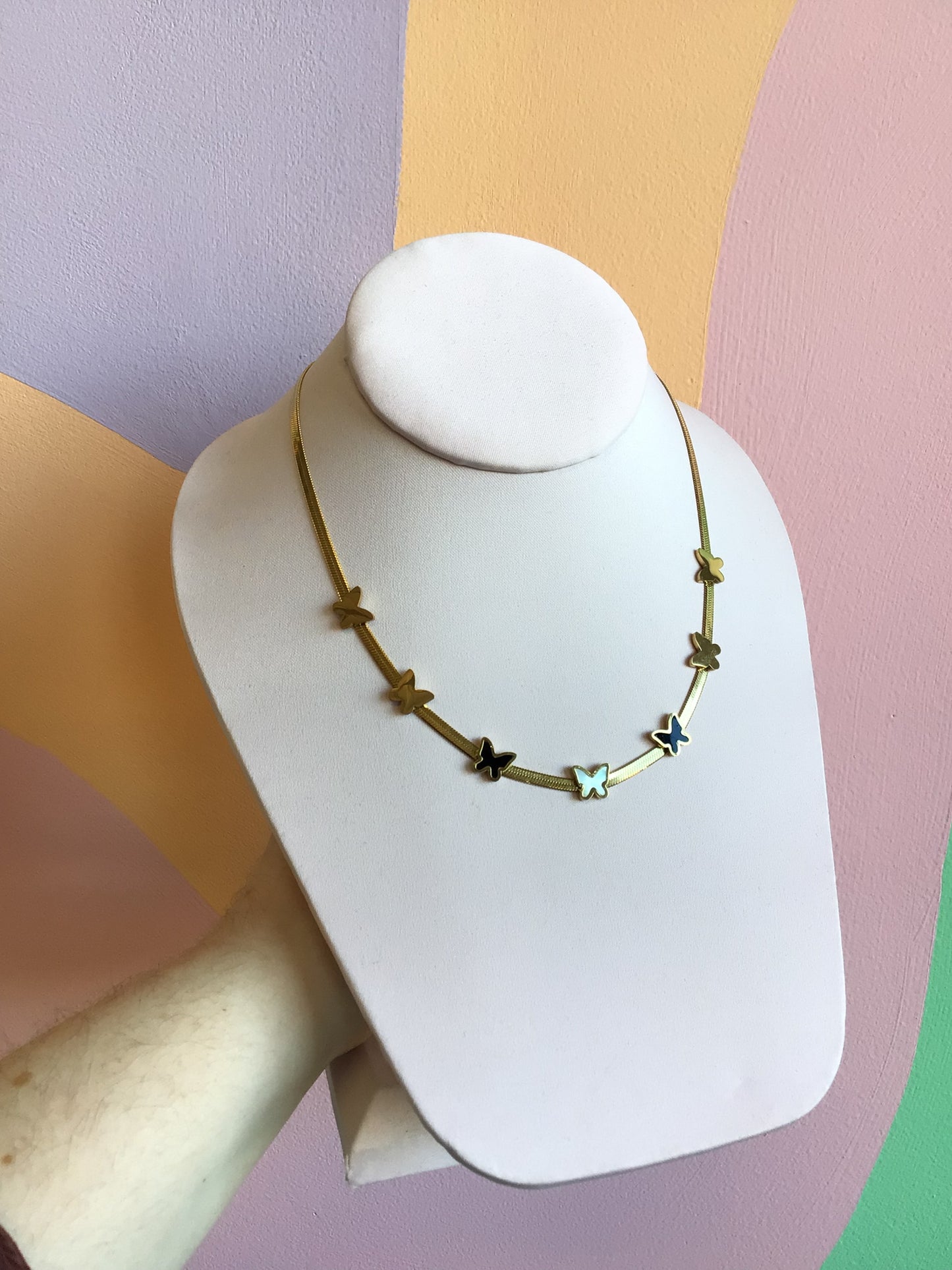 Flat Butterfly Titanium Chain shown on product stand in front of wavy colorful background