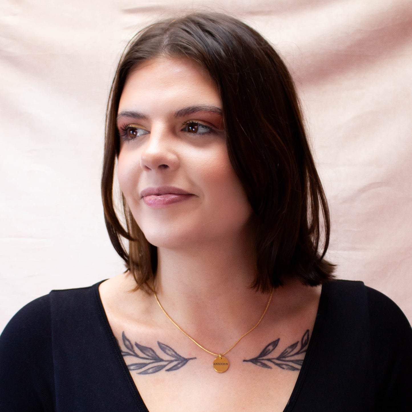 full model portrait displaying gold engraved "Anxious" necklace