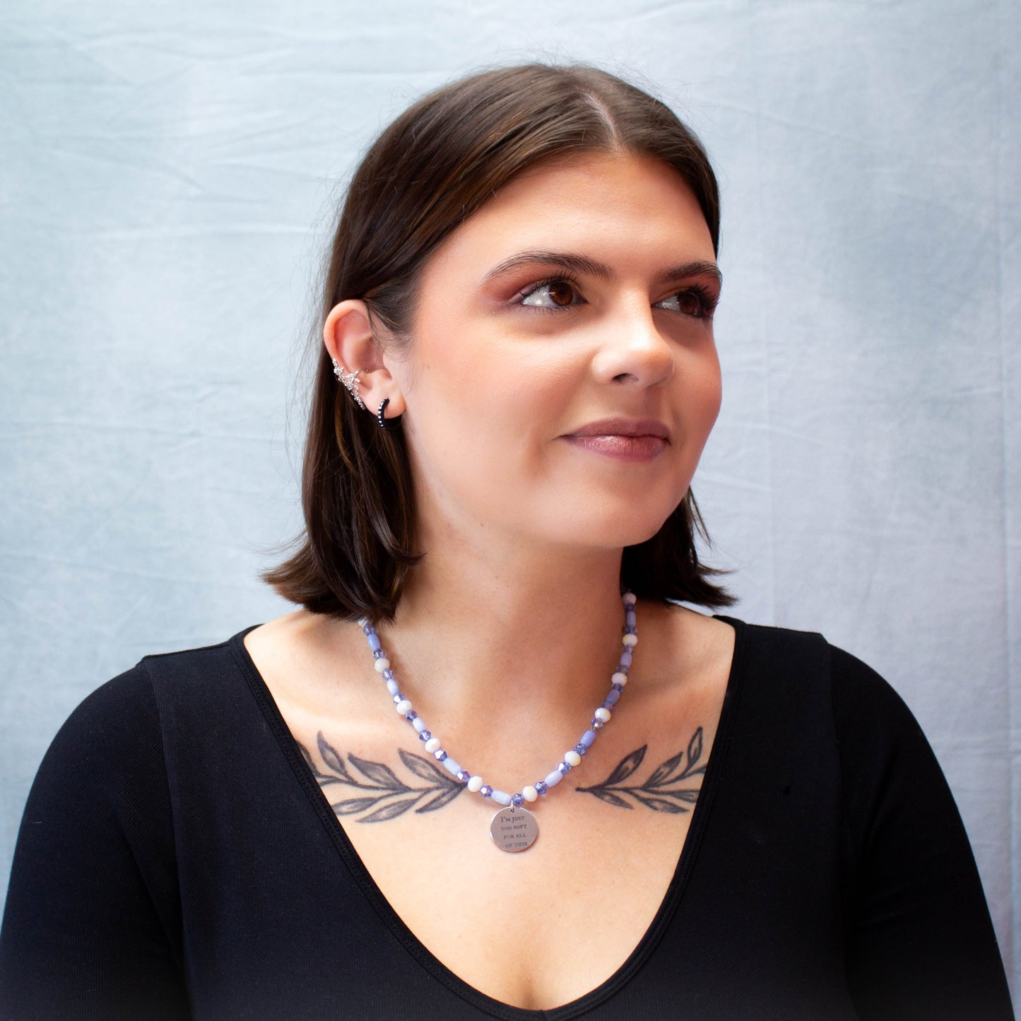 full model portrait displaying engraved charm necklace with lavender beaded chain