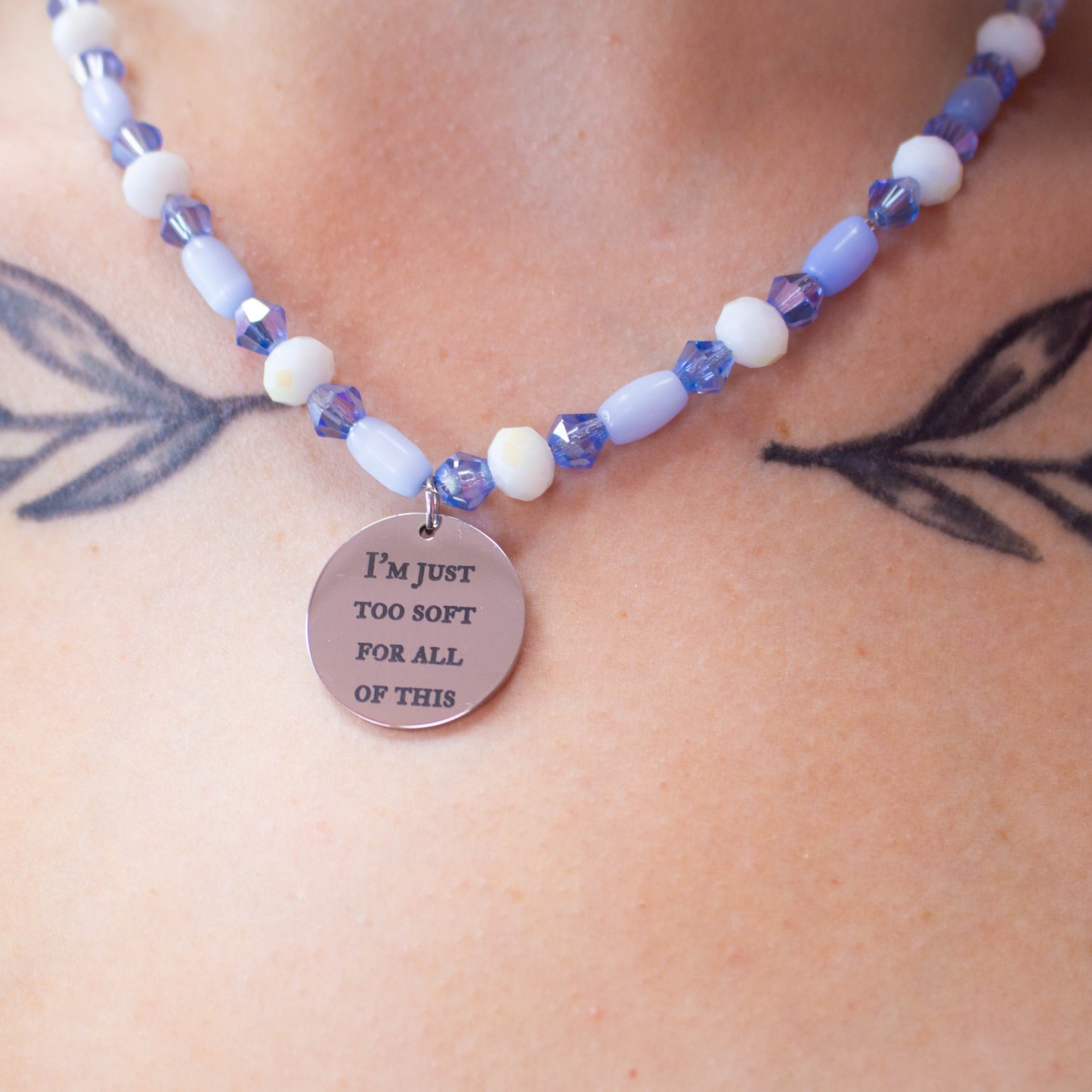 Close up of engraved charm reading "I'm just too soft for all of this" from Taylor Swift's song Sweet Nothing