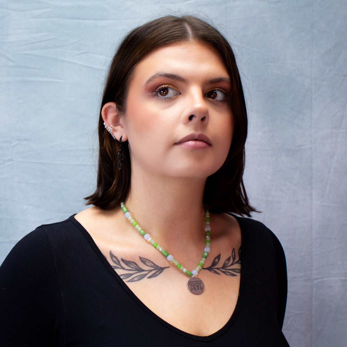 full model portrait of green beaded necklace with engraved charm
