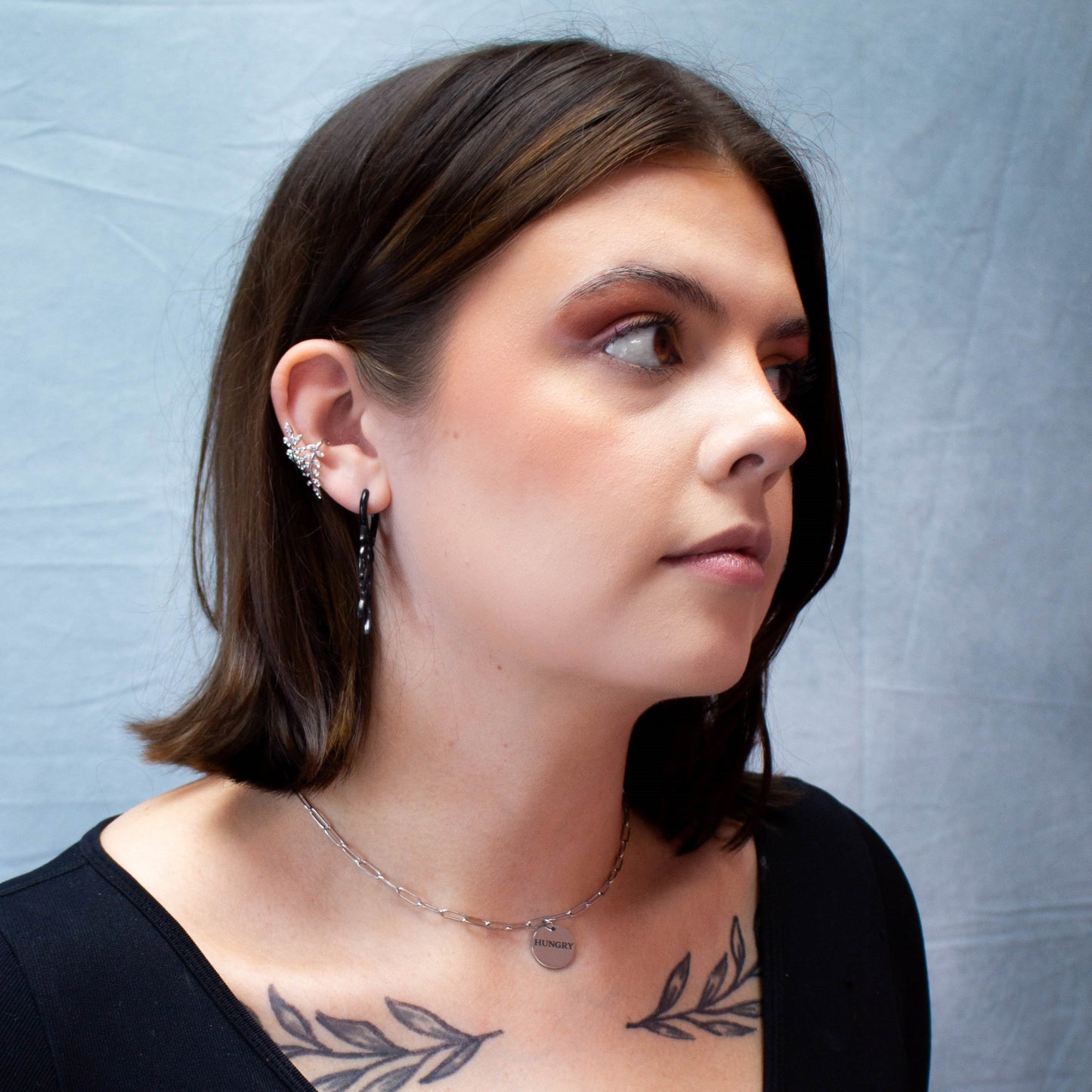 Full model portrait wearing silver "Hungry" engraved titanium necklace
