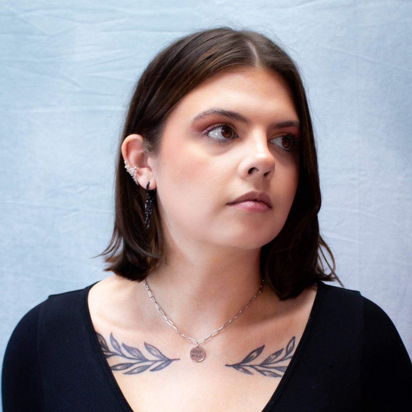 Portrait of model wearing silver "Stay Wild" engraved necklace