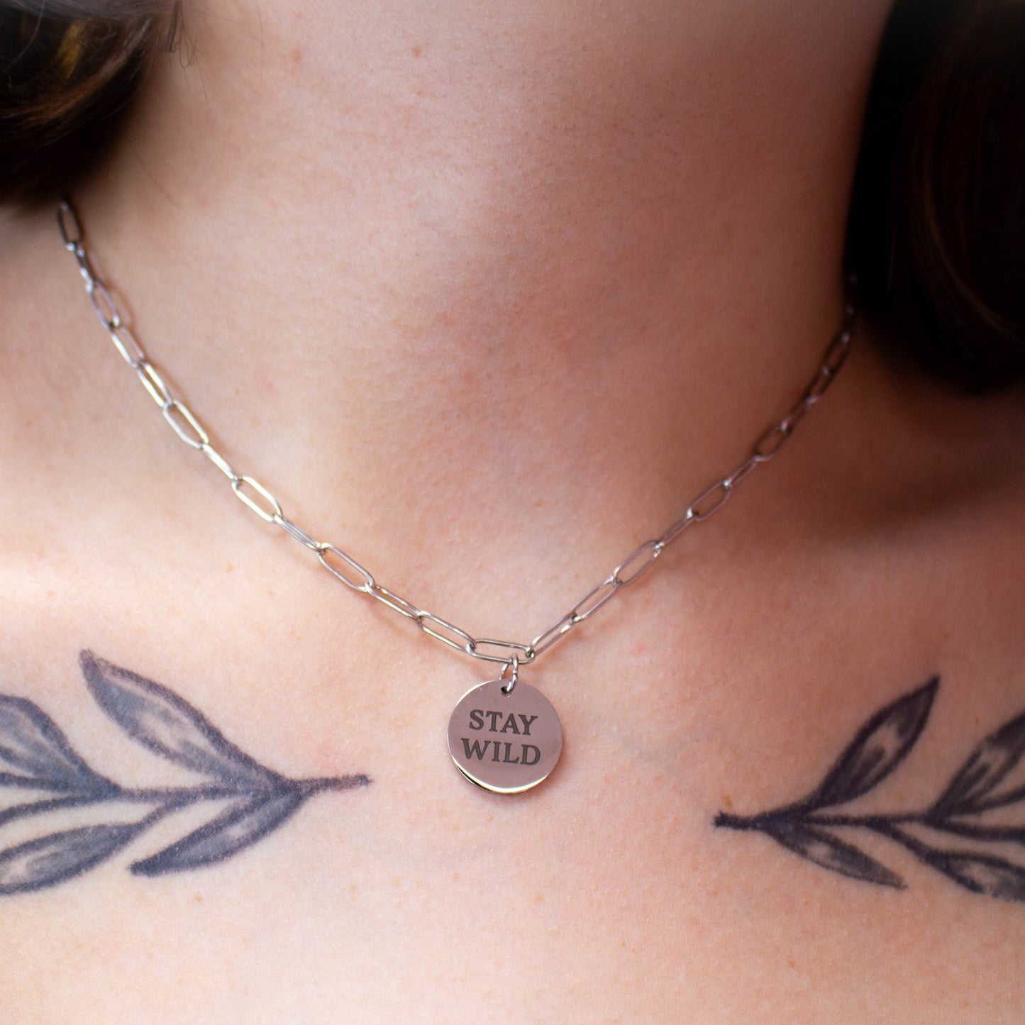 Close up of engraved "Stay Wild" necklace on model's neck