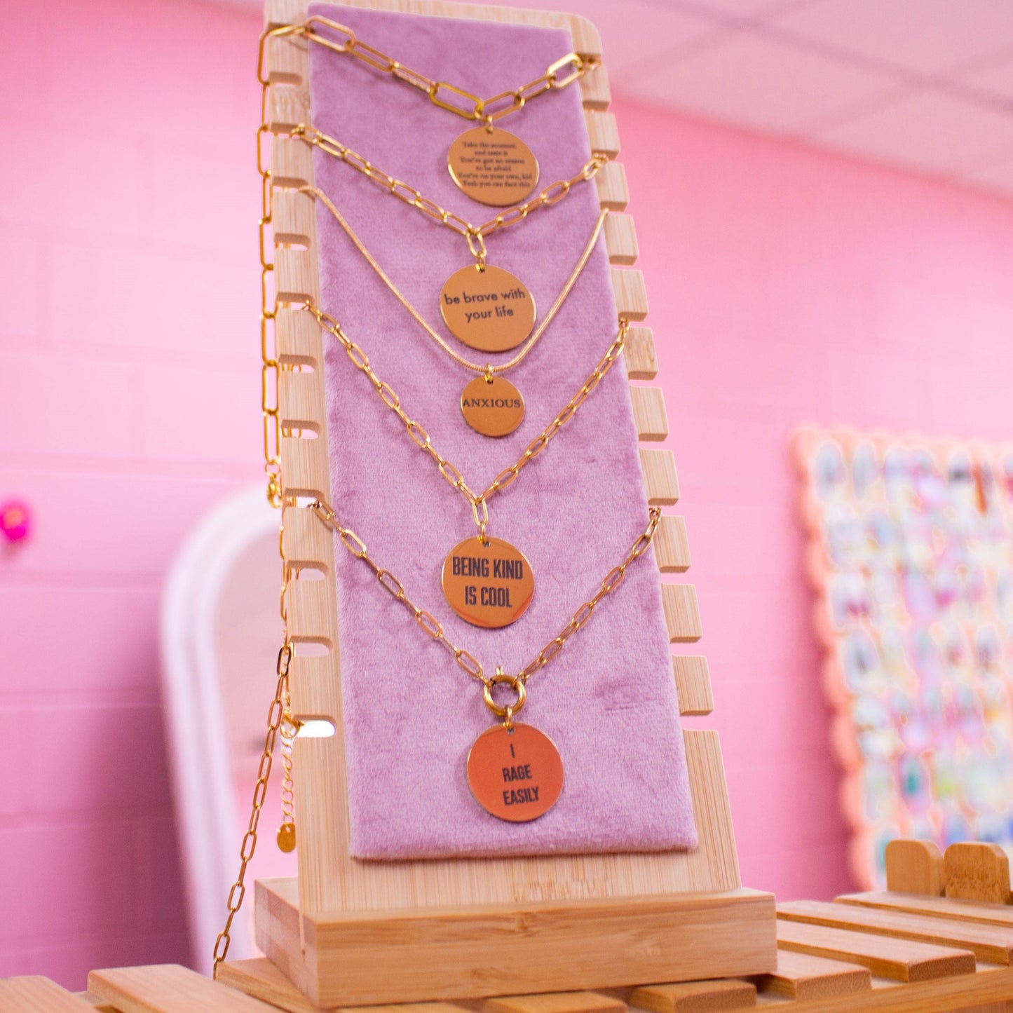 Multiple gold engraved necklaces on product stand