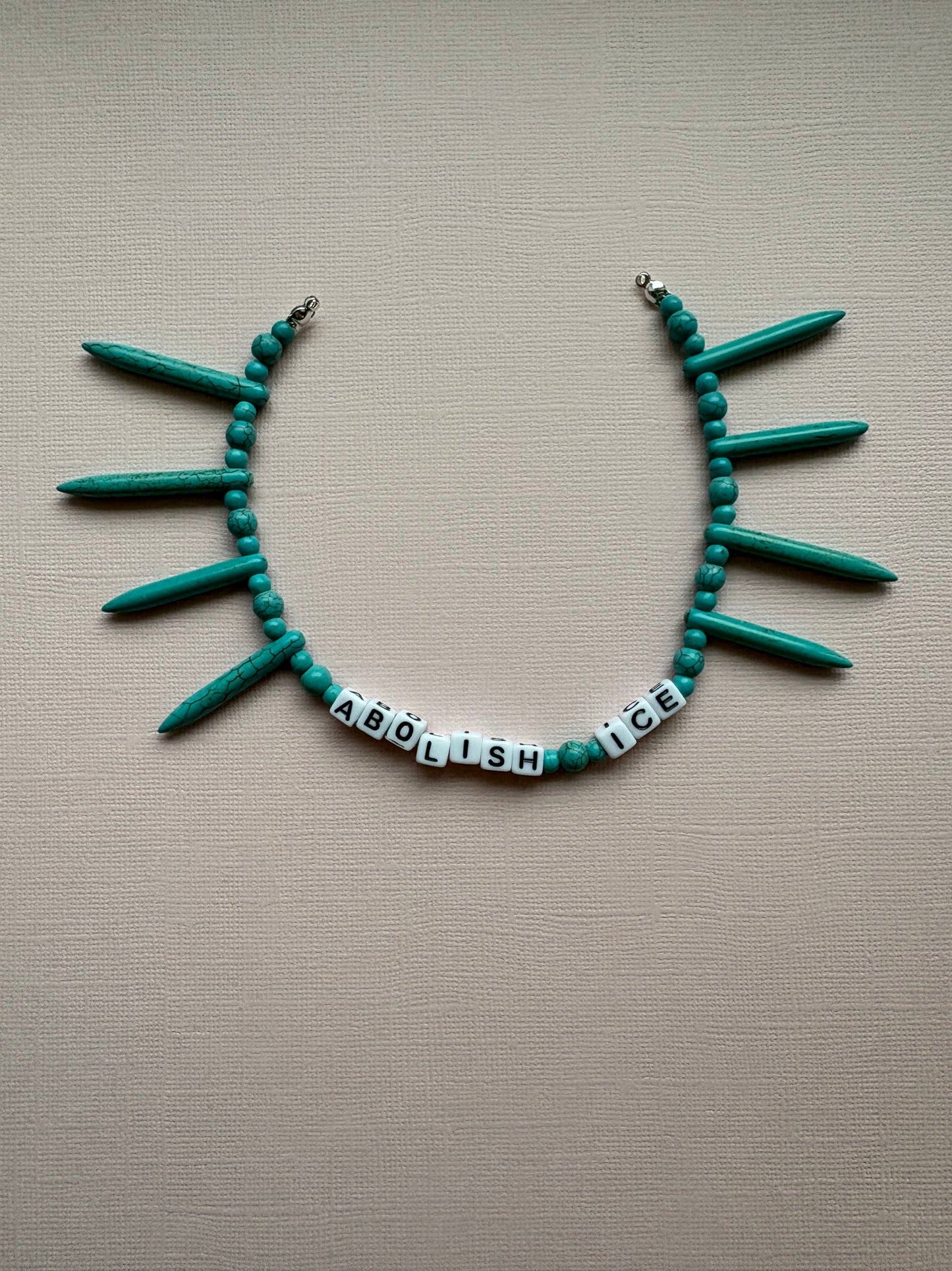 Abolish ICE pointed turquoise bag charm